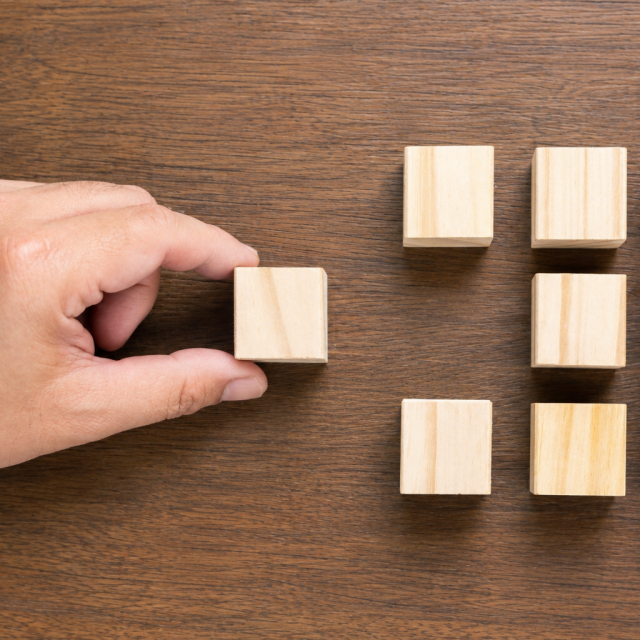 hand_placing_wooden_cube_grid-square